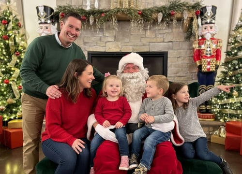 An image of a family taking a picture with Santa at his workshop An image of a family taking a picture with Santa at his workshop
