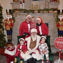 An image of a family posing with Santa at his workshop.