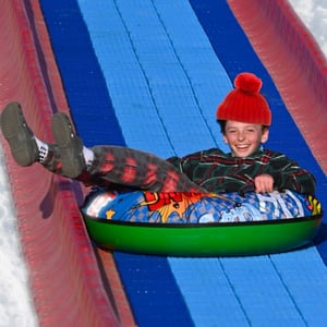 kid enjoying snowless tube slide at the grand opening event of Christmas Carnival of Lights kid enjoying snowless tube slide at the grand opening event of Christmas Carnival of Lights