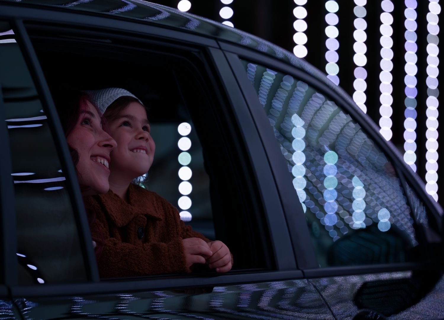 mom & daughter looking out at the dazzling lights at the Christmas Carnival of Lights mom & daughter looking out at the dazzling lights at the Christmas Carnival of Lights