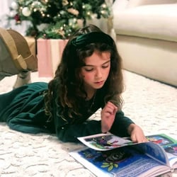 An image of a girl reading Evy the Evergreen Finds His Shine. An image of a girl reading Evy the Evergreen Finds His Shine.