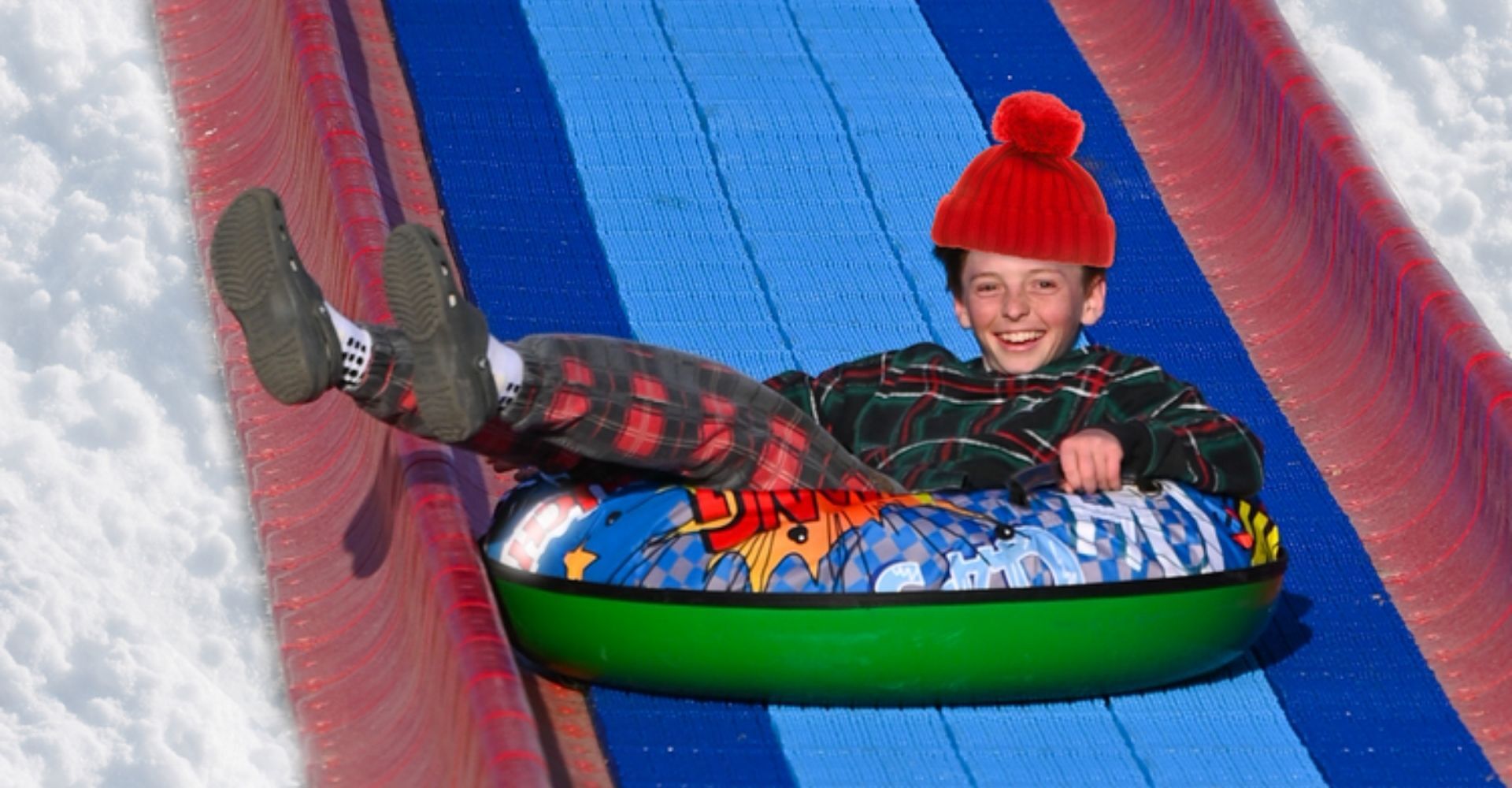 kid sliding down the snowless tube slide at Christmas Carnival of Lights kid sliding down the snowless tube slide at Christmas Carnival of Lights